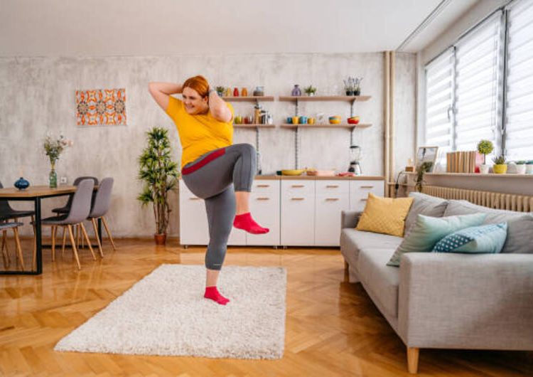 Young plus size woman exercising in the morning at home.